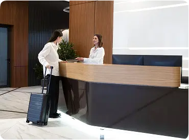 Business traveler checking into a modern hotel reception desk for day-use hourly room rental.